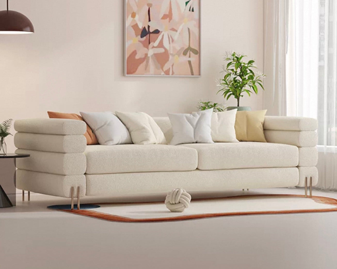Modern living room with a beige sofa, abstract art, and a plant.