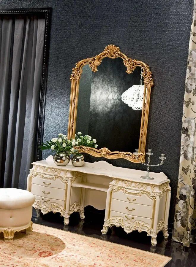 Decorative vanity with ornate mirror against a dark wall