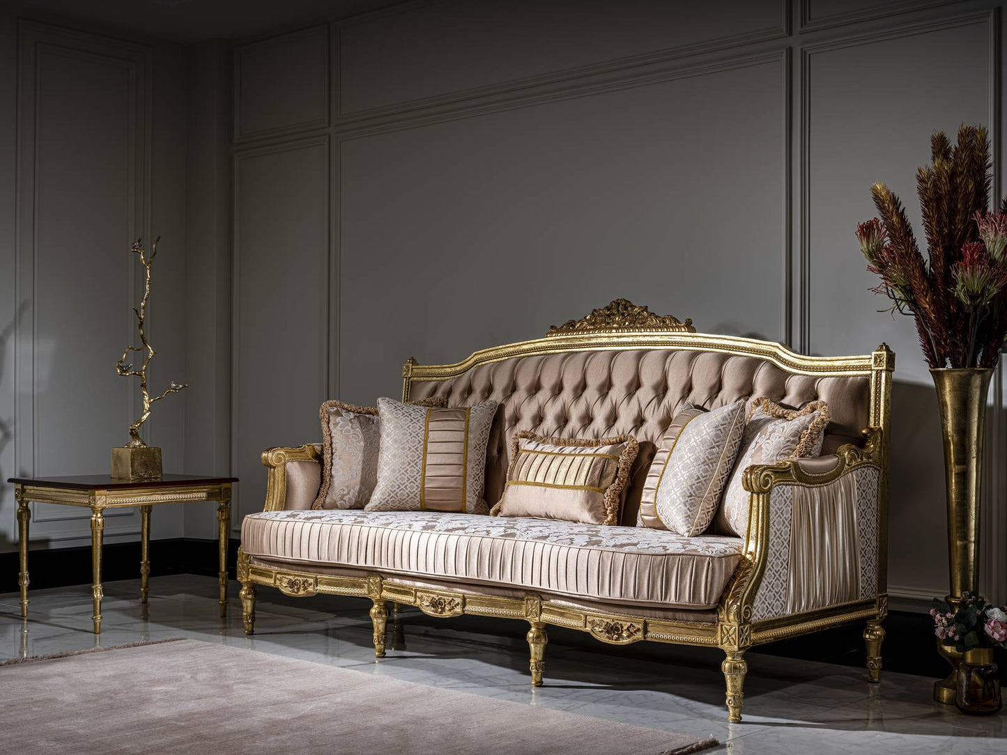Luxurious sofa with gold accents in a room with a table and decorative items.