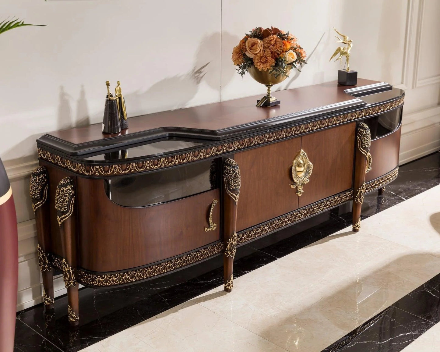 A brown walnut finish French TV console cabinet with gold detailing, hand carved with intricate details, doors with hinge and a space for tv unit.