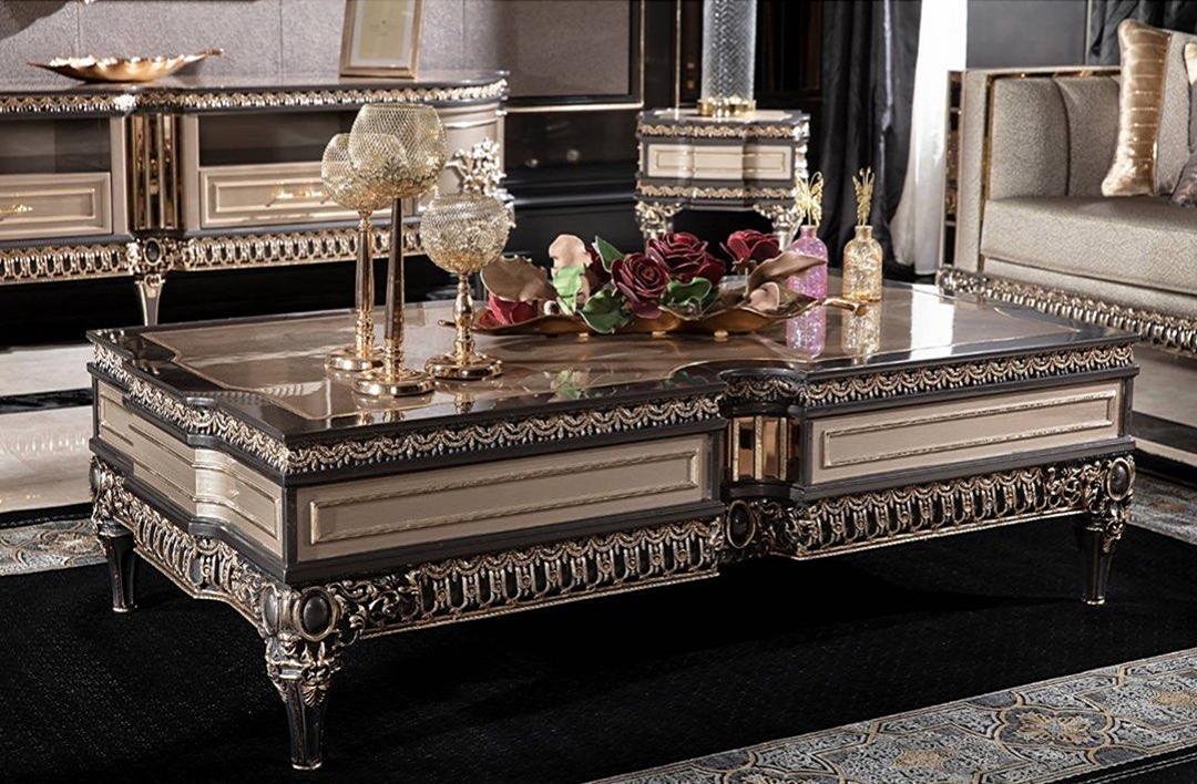 A luxurious French design coffee table made of mahogany, featuring intricate carvings and a polished finish, displayed in a lavishly decorated living room setting.