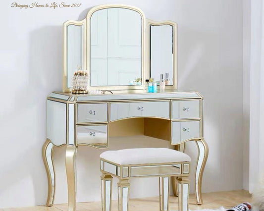 A luxurious vanity set with a mirrored surface, gold-colored legs, and a stool. The set is displayed against a white background.