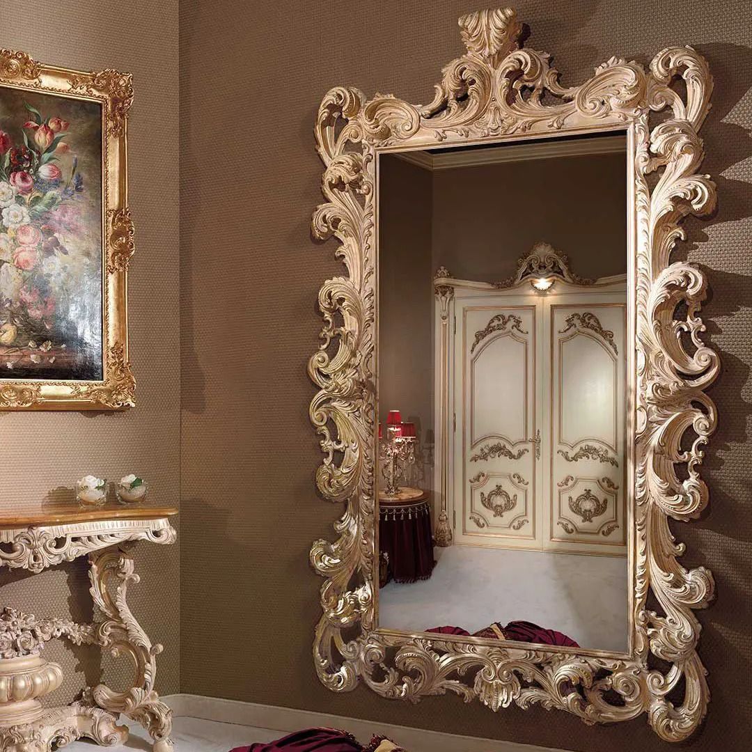 Decorative ornate mirror with intricate detailing on a wall.