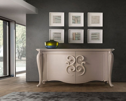 Decorative console table with ornate design in a room with framed art on the wall.