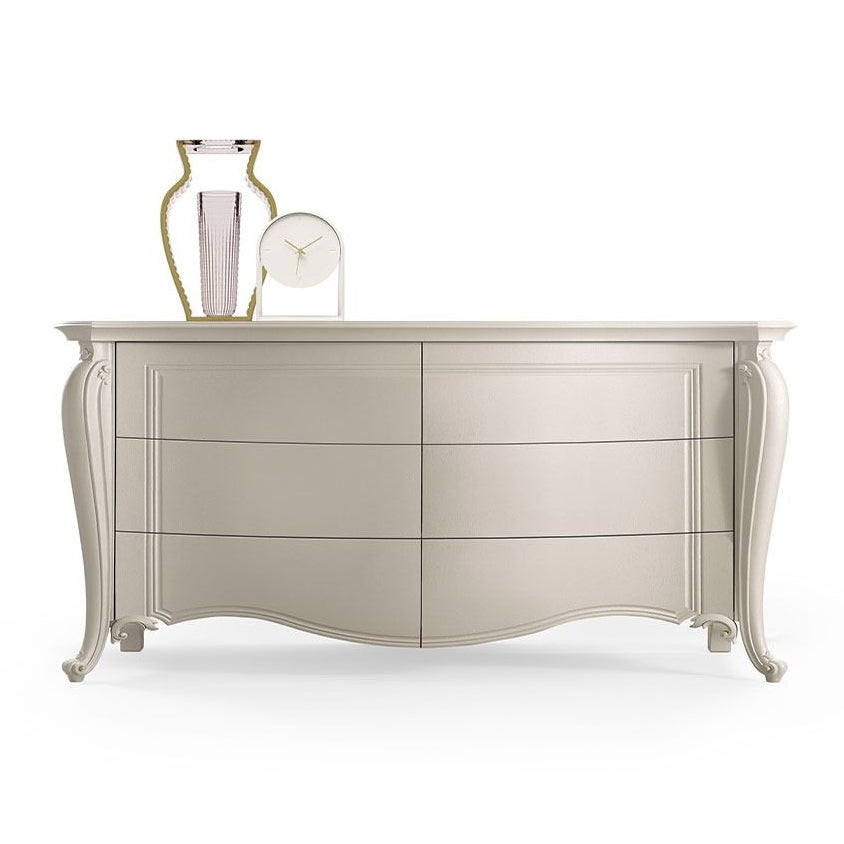 Beige dresser with decorative items on a white background