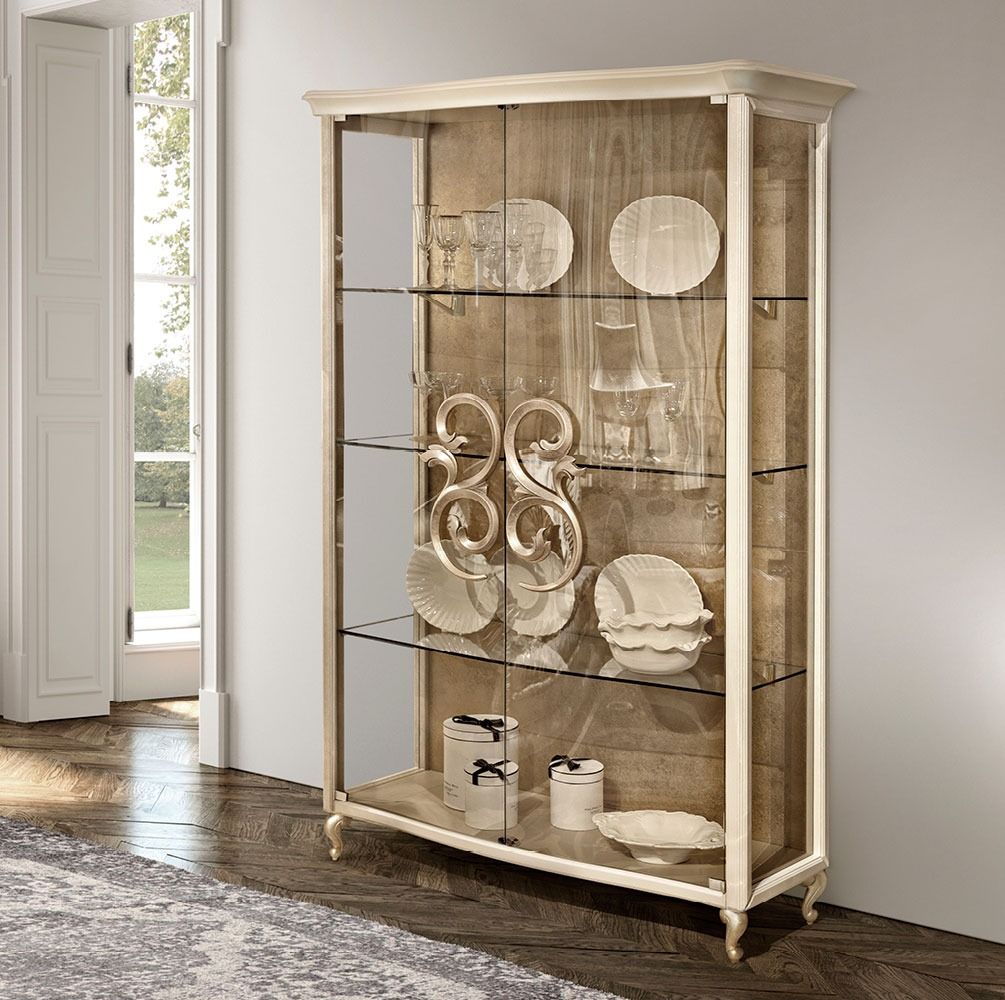 Display cabinet with decorative items in a room with a door leading outside.