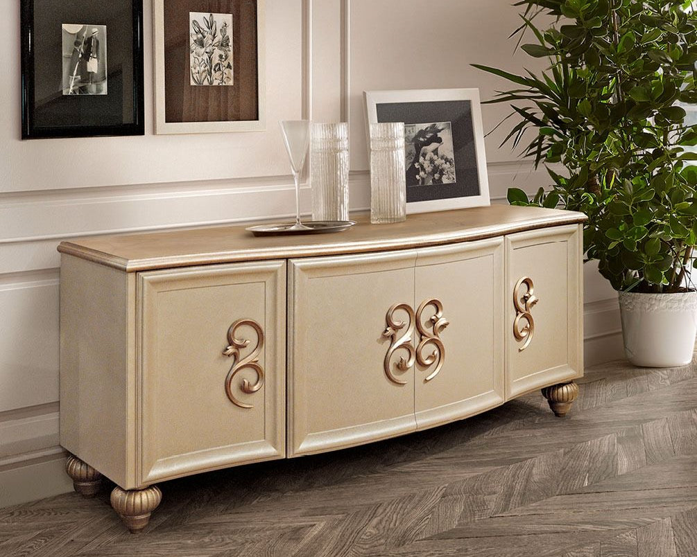 Beige sideboard with decorative elements in a room with framed pictures and a plant.