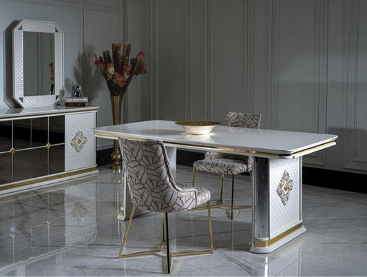 A luxurious dining set featuring a mirrored dining table with gold trimmings and matching chairs, set against a sophisticated grey background.