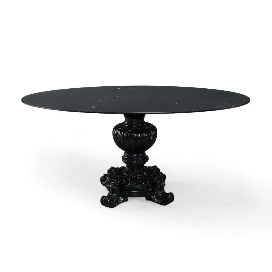 Black marble table with decorative pedestal base on a white background