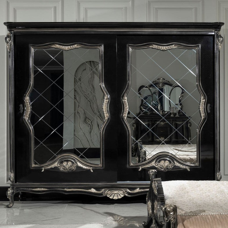 Elegant baroque style black wardrobe with intricate carved details and a sterling silver mirror, positioned in a luxurious bedroom setting.