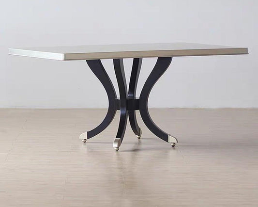 A modern luxury style rectangular dining table with a white tabletop and dark wood base with metal accents.