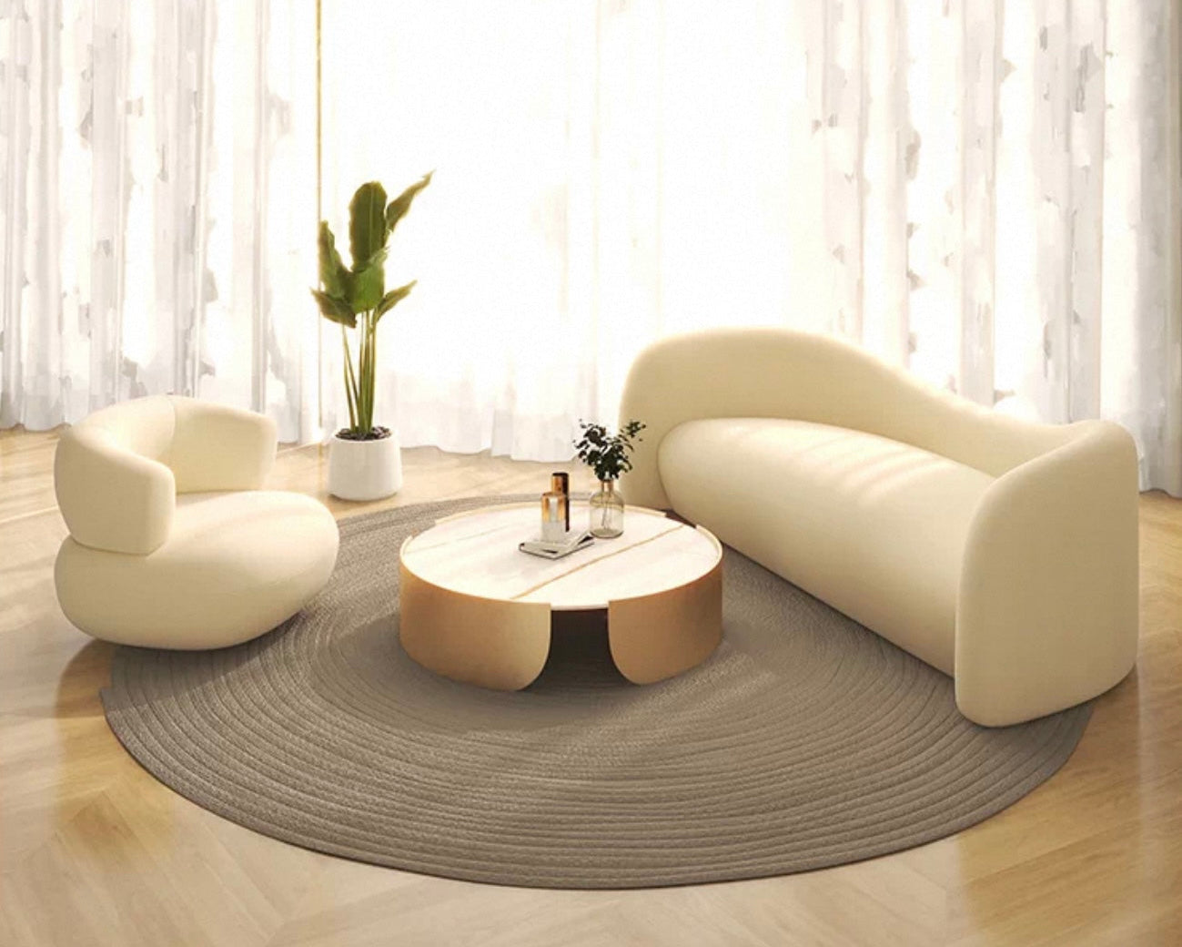 Modern living room with a beige sofa, armchair, and round coffee table on a wooden floor.