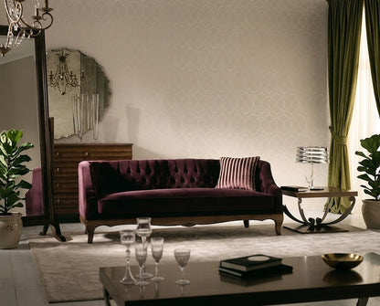 A classic tufted velvet sofa in deep burgundy, styled in a luxurious living room with green curtains, a patterned wall, and a dark wood coffee table in the foreground.