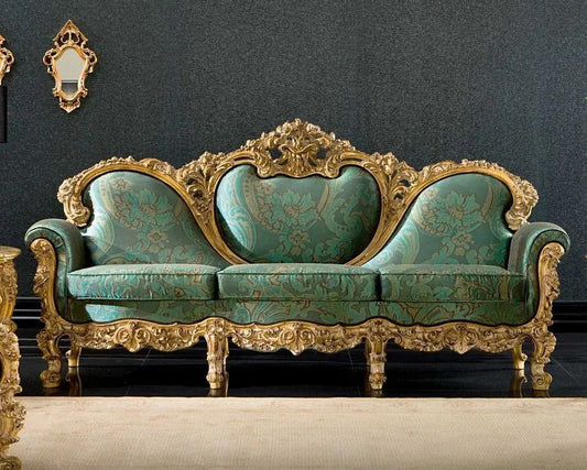Decorative sofa with gold frame and teal fabric against a dark wall.