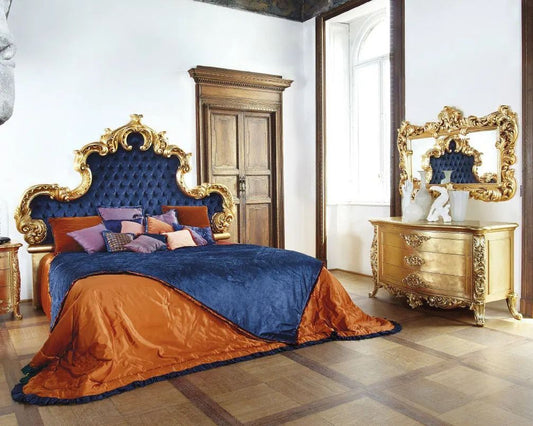 Luxurious bedroom with ornate bed and dresser in a classical style.