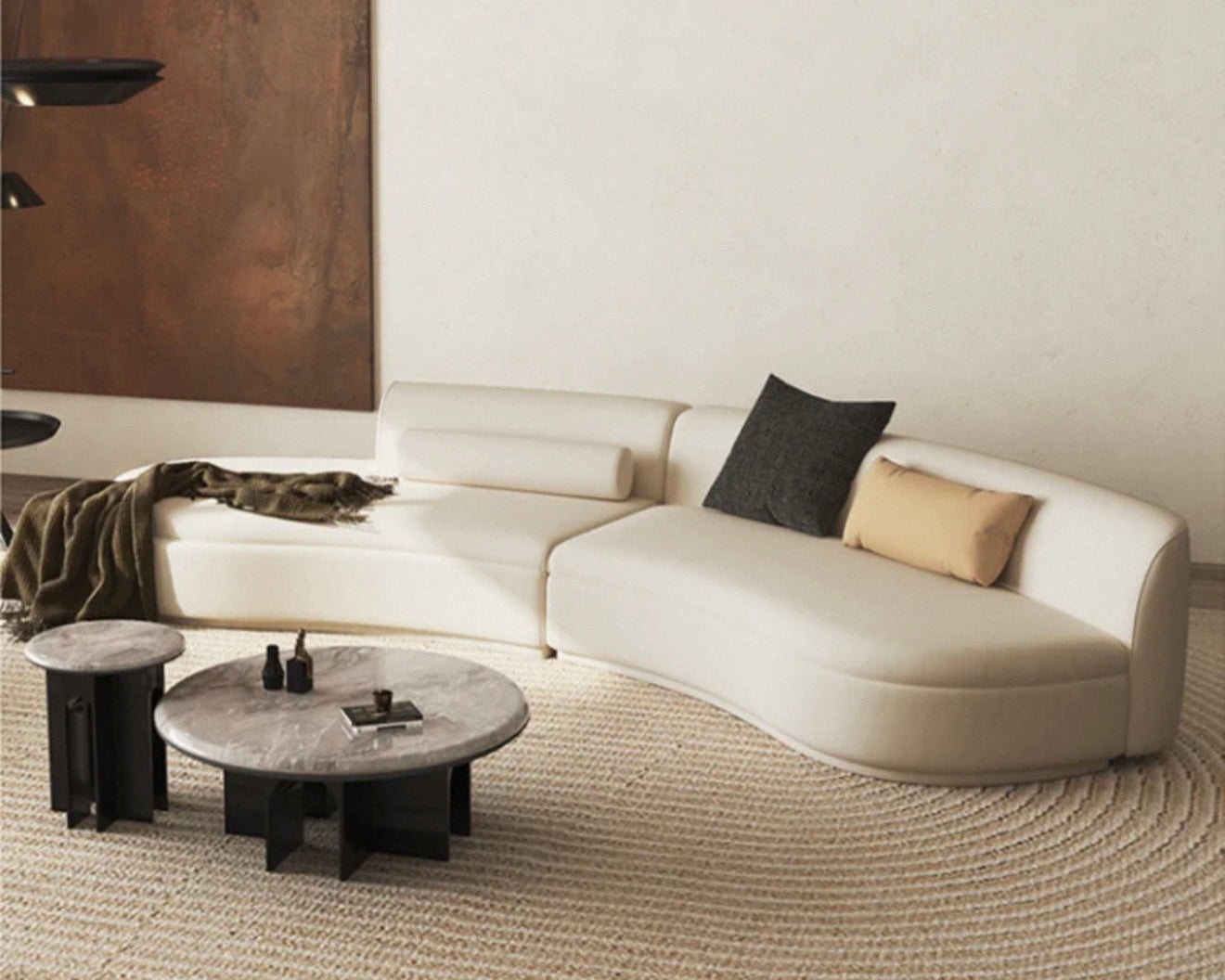 Modern living room with a white sectional sofa, coffee table, and decorative pillows.