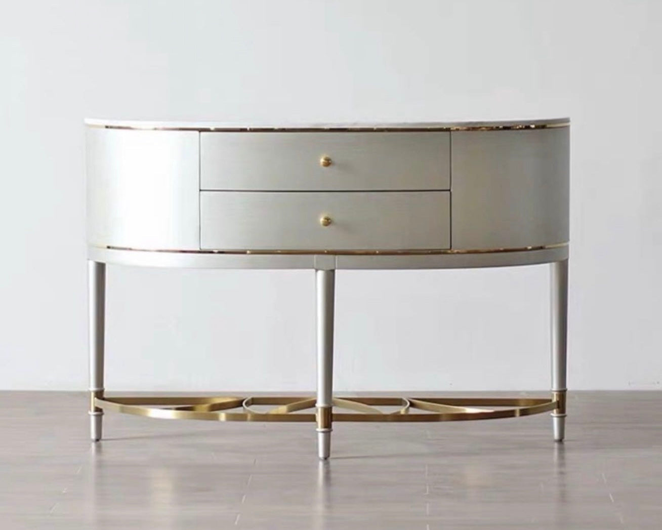 Silver and gold round console table against a white wall