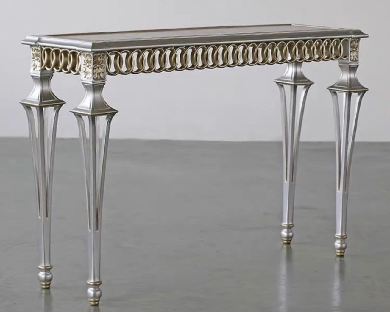 Decorative console table with intricate design on a plain background
