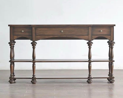 Wooden console table with three drawers on a plain background