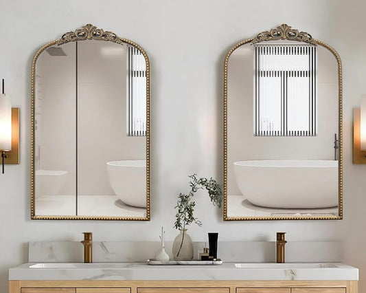 Bathroom vanity with wooden cabinets, white countertop, and decorative mirrors.