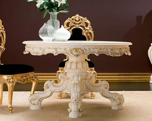 Decorative white table with gold accents in a room with a dark brown wall.