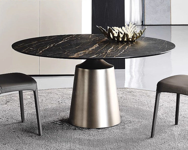 Modern round dining table with marble top and metallic base in a stylish room.