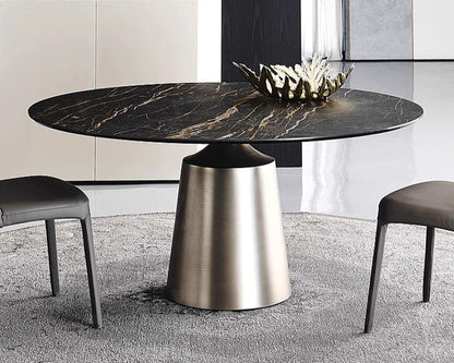 Modern round dining table with marble top and metallic base in a stylish room.
