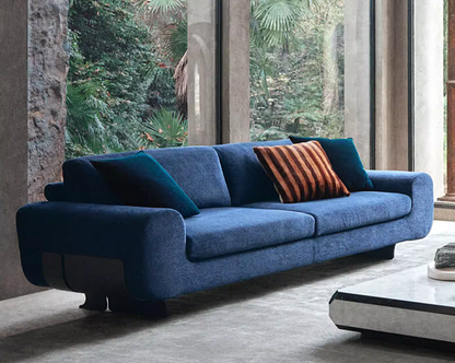 Custom made blue modern stainless steel legs sofa with a striped pillow in a modern living room.