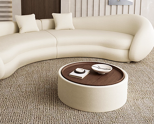 Beige sectional sofa with a round wooden coffee table upholstered in velvet in a living room setting.