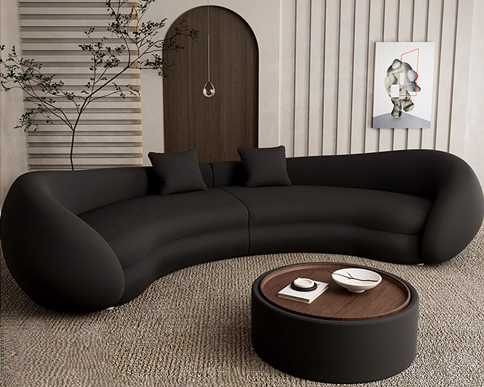 Modern black sofa in a living room with a coffee table and decorative elements.