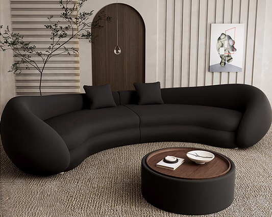 Modern black sofa in a living room with a coffee table and decorative elements.
