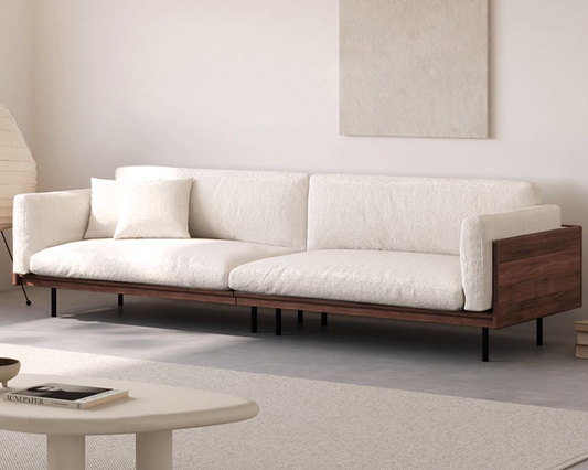Modern white sofa with wooden frame in a minimalistic living room.