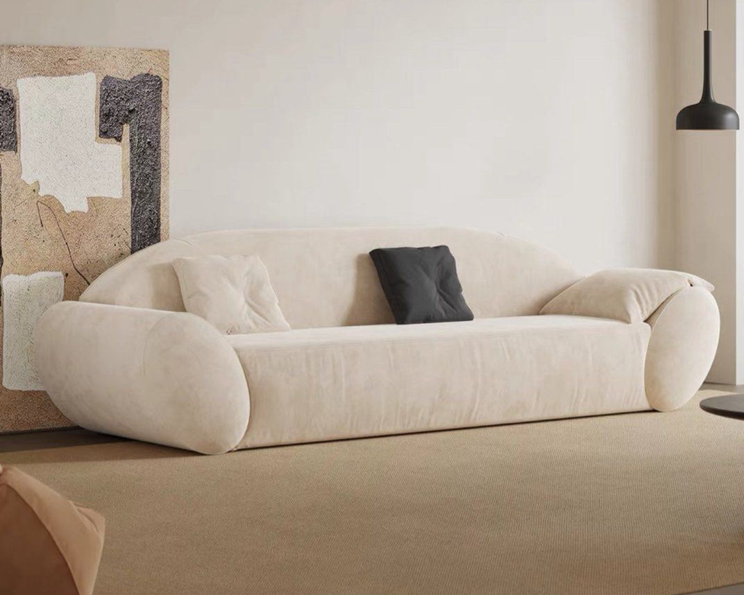 Beige sofa in a modern living room with abstract art and pendant light.