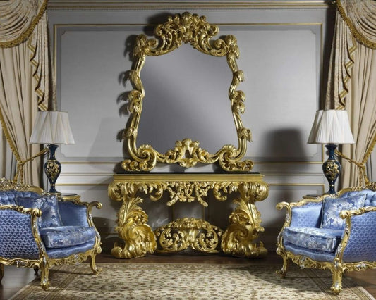 Opulent interior with ornate gold console table and blue chairs.