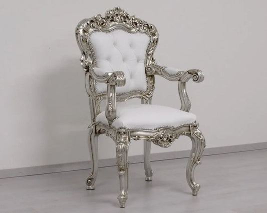Decorative silver chair with white cushion on a plain background