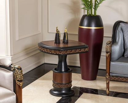 A French side table with a rich walnut finish and gold detailing, featuring a round top with a decorative edge and a rectangular base, placed in a room with an elegant interior design.