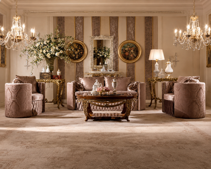 An elegant, symmetrical living room showcasing a luxury furniture set in dusty rose and gold. The set includes a central carved wooden coffee table, a matching three-seater sofa, two matching barrel armchairs, side tables, and decorative accents under two crystal chandeliers.