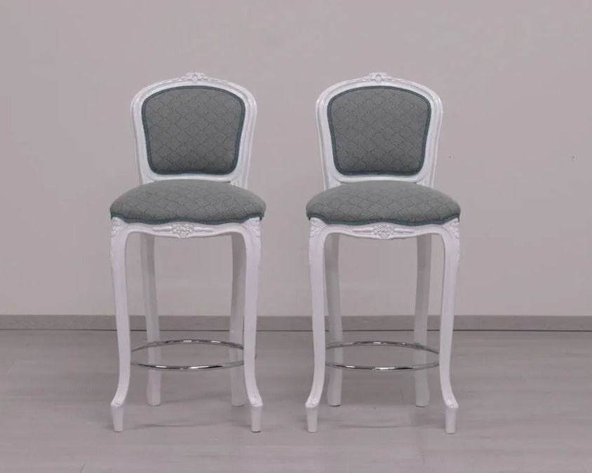 Two white bar stools with gray seats on a plain background