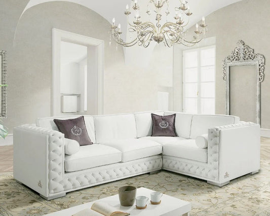 White sectional sofa in a stylish living room with a chandelier and decorative mirror.