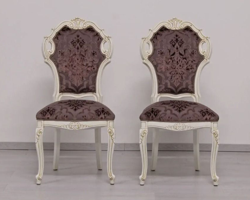 Two ornate chairs with floral patterns on a plain background