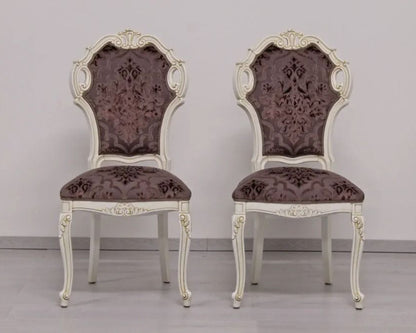 Two ornate chairs with floral patterns on a plain background