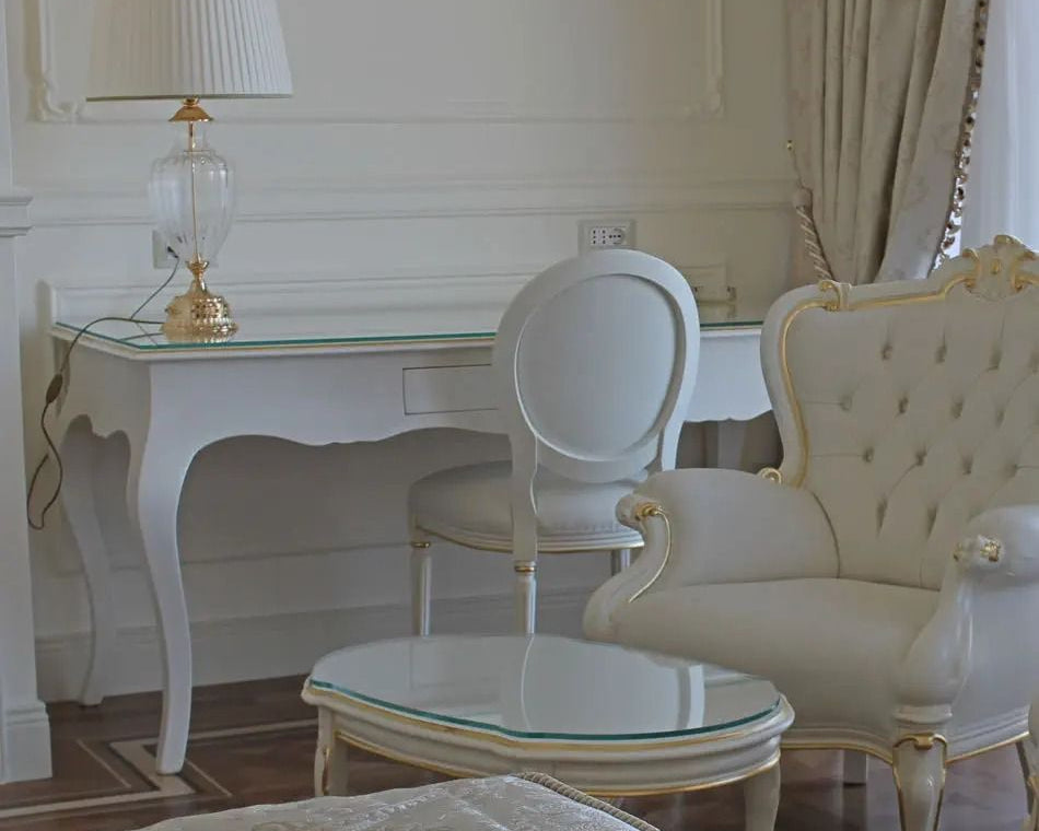 Elegant interior with white furniture, including a table and chairs, in a room with light-colored walls and curtains.