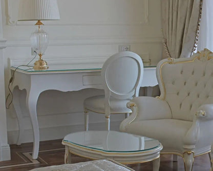 Elegant interior with white furniture, including a table and chairs, in a room with light-colored walls and curtains.