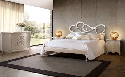 Modern bedroom with white bed and dresser against a neutral wall.