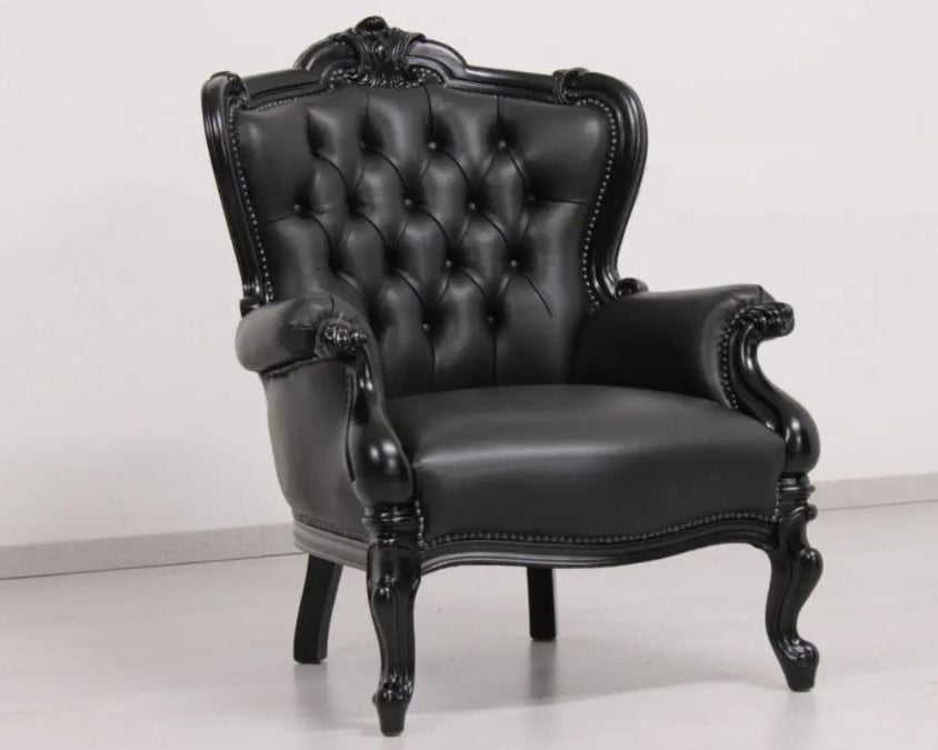 Black leather armchair with ornate design on a white background