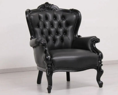 Black leather armchair with ornate design on a white background