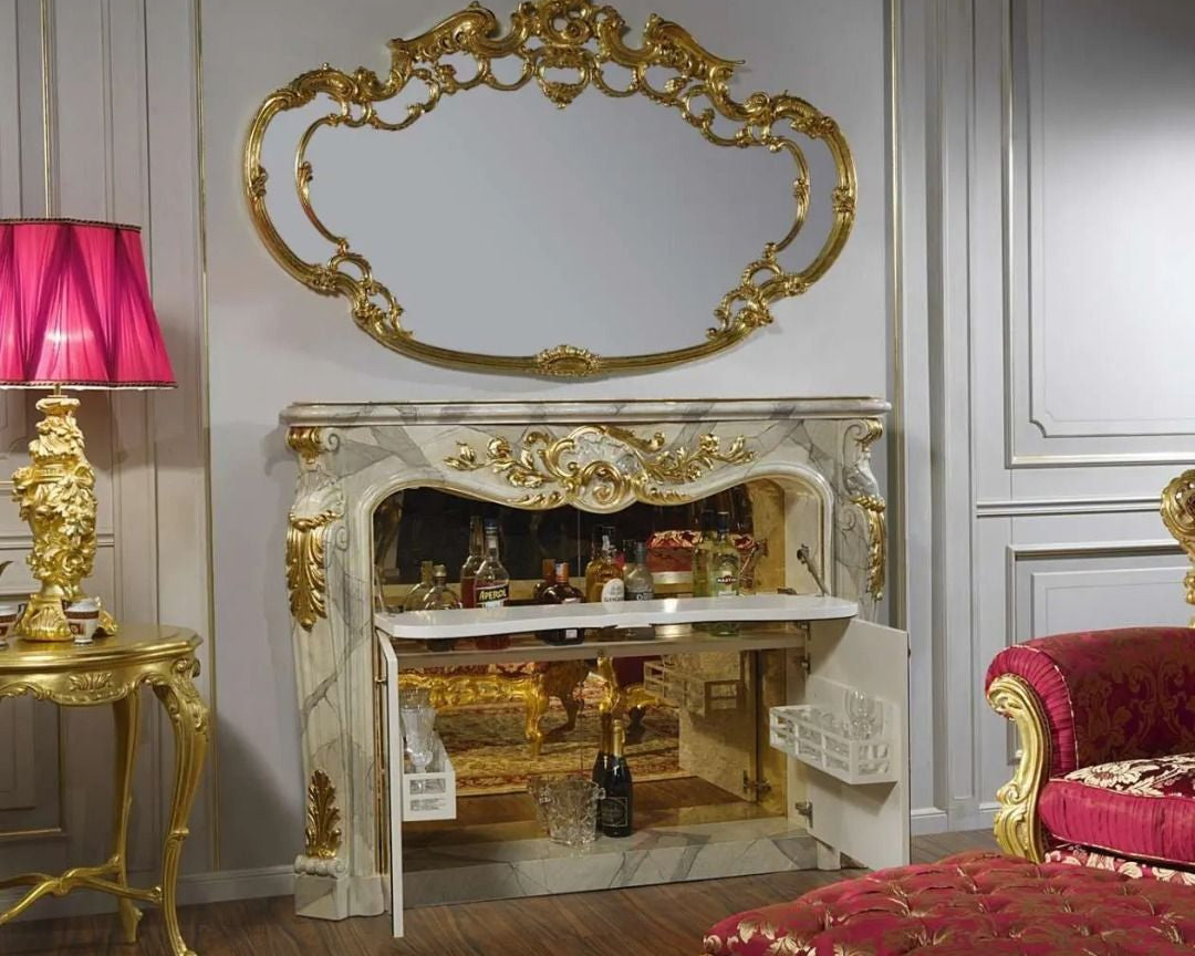 Luxurious interior with ornate fireplace, gold mirror, and red chair.