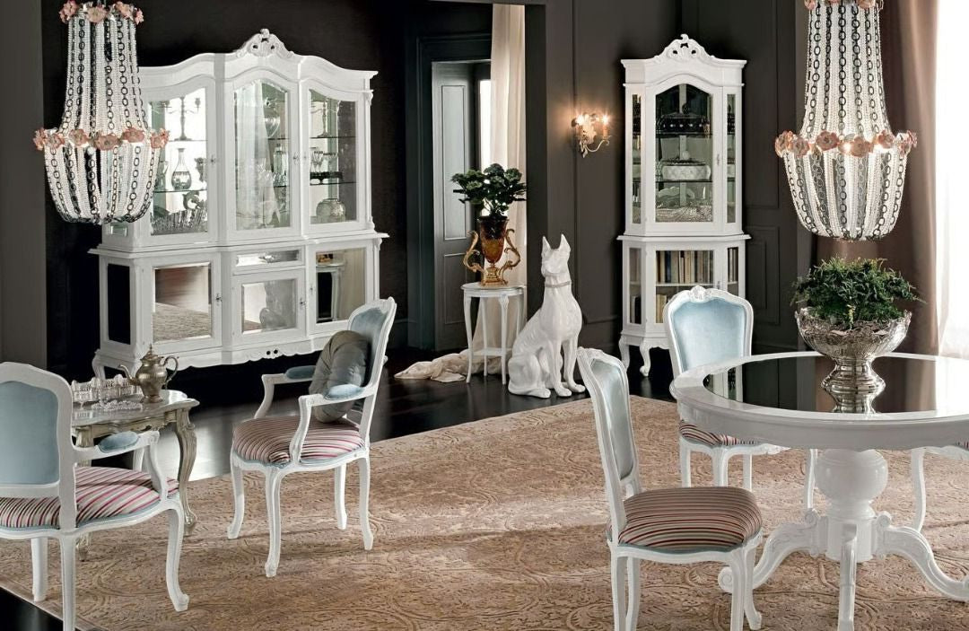 Dining room with white furniture, chandeliers, and decorative items.