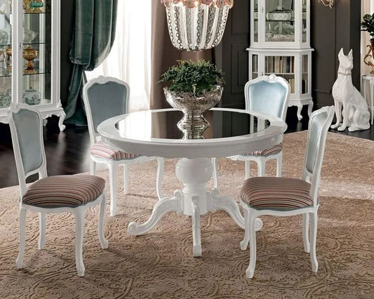 Round dining table with four chairs in a room with decorative elements.